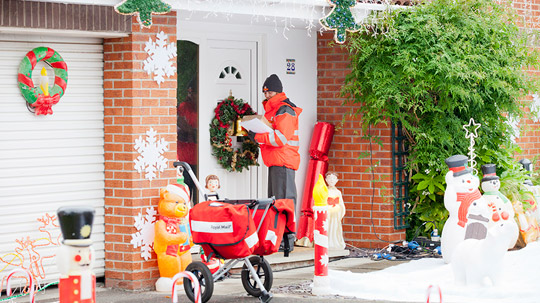 Postwoman delivering mail at Christmas